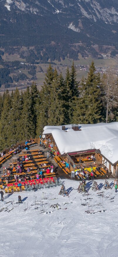 Drohnenaufnahme der Schoarlhütte am Hauser Kaibling mit Blick auf die umliegenden verschneiten Wälder und das Ennstal. | © Hauser Kaibling