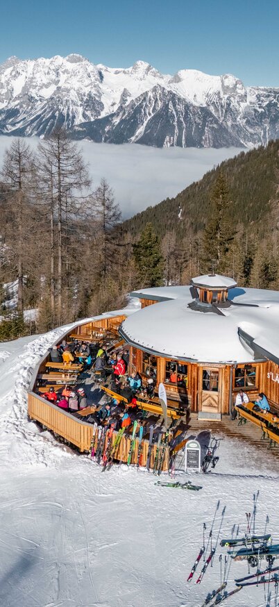 Drone shot of the s'Lärchenpavillon in the middle of the snow-covered mountains at Hauser Kaibling. | © Alpine Genusswelten 